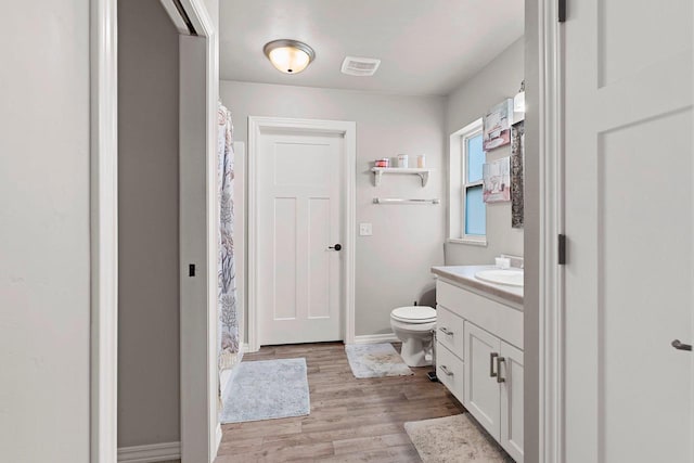 830 Roth Rd, De Pere, WI 54115 - bathroom featuring toilet, baseboards, visible vents, wood finished floors, and vanity
