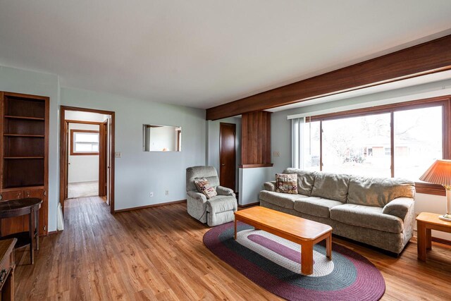 living area with light wood-style flooring and baseboards
