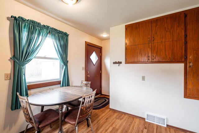 dining space with baseboards, visible vents, and light wood-style flooring
