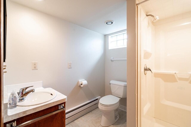 bathroom featuring tile patterned floors, toilet, vanity, walk in shower, and baseboard heating