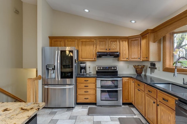 kitchen with a sink, brown cabinetry, stainless steel appliances, lofted ceiling, and under cabinet range hood