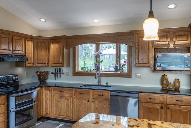 kitchen with appliances with stainless steel finishes, a sink, brown cabinetry, decorative light fixtures, and under cabinet range hood