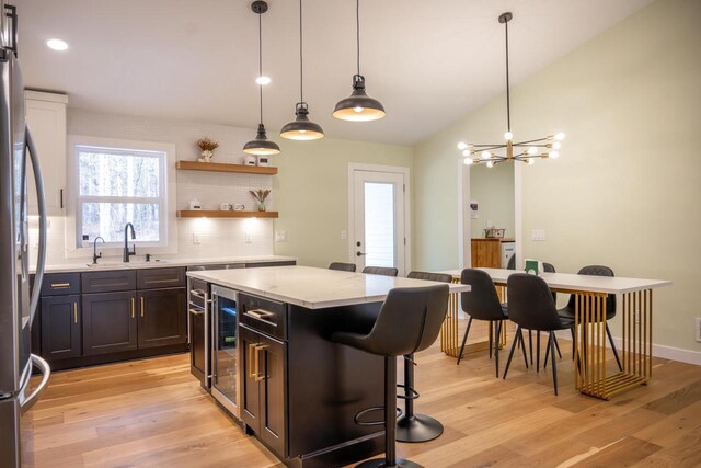W3090 Yellow Banks Trl, Nekoosa, WI 54457 - kitchen featuring wine cooler, a kitchen bar, a kitchen island, light wood-type flooring, and stainless steel fridge