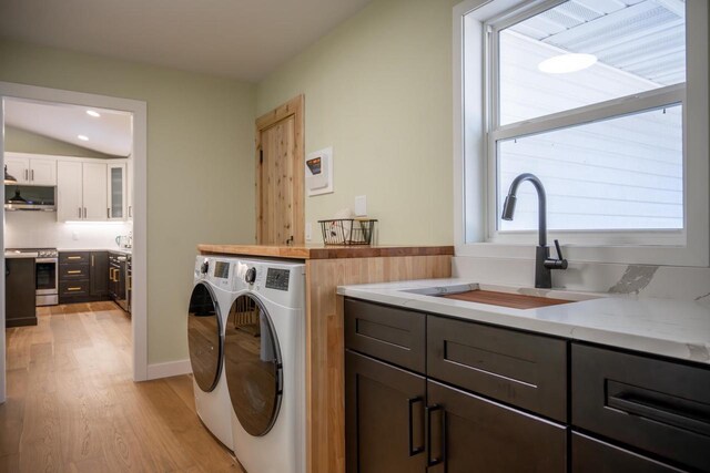 W3090 Yellow Banks Trl, Nekoosa, WI 54457 - laundry area with separate washer and dryer, light wood-style flooring, a sink, and cabinet space