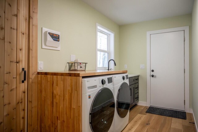 W3090 Yellow Banks Trl, Nekoosa, WI 54457 - laundry area with light wood finished floors, a sink, baseboards, cabinet space, and washer and dryer