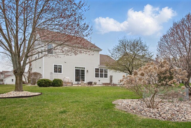 rear view of property with a yard