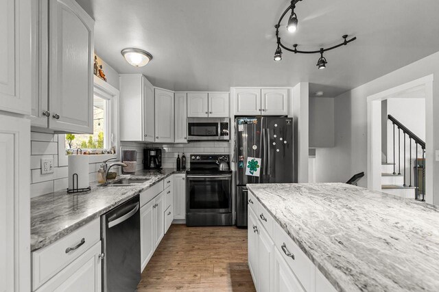 1442 Traeger St, Green Bay, WI 54304 - kitchen featuring backsplash, stainless steel appliances, white cabinets, and a sink