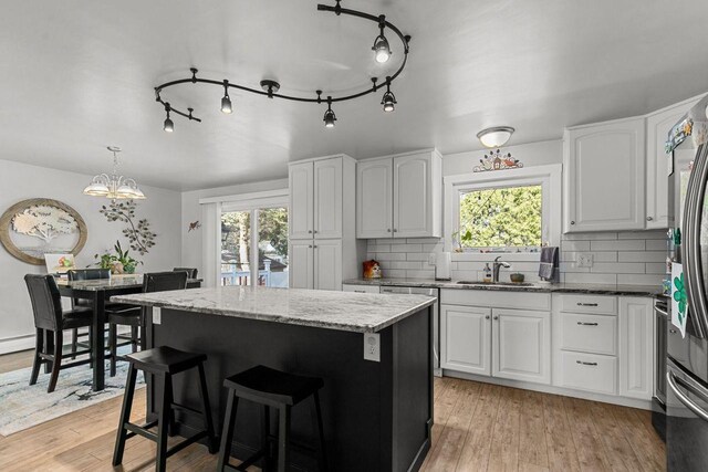 1442 Traeger St, Green Bay, WI 54304 - kitchen featuring light stone countertops, decorative backsplash, a sink, and a healthy amount of sunlight