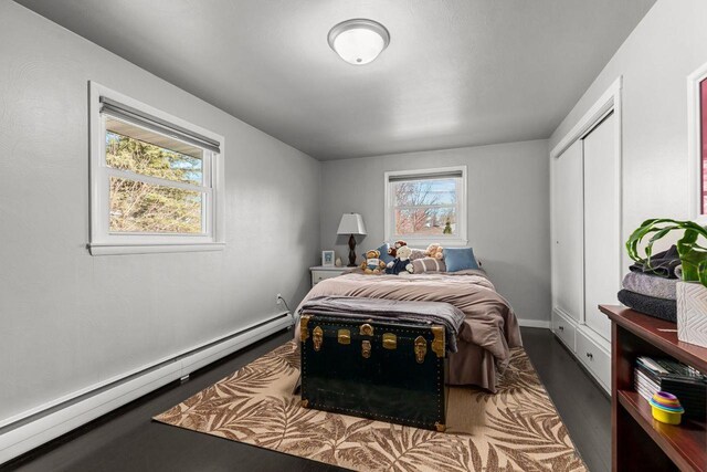 1442 Traeger St, Green Bay, WI 54304 - bedroom featuring a baseboard radiator, baseboards, wood finished floors, and a closet
