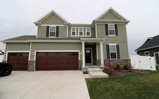 1677 Liatris Dr, Sun Prairie, WI 53590 - craftsman-style house featuring fence, driveway, stone siding, and a front lawn