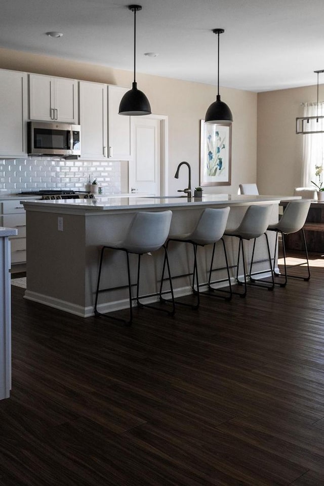 1677 Liatris Dr, Sun Prairie, WI 53590 - kitchen featuring dark wood-style flooring, stainless steel appliances, and a kitchen bar