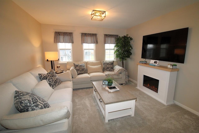 1677 Liatris Dr, Sun Prairie, WI 53590 - living room with baseboards, light carpet, and a warm lit fireplace