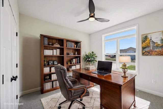 office area with light carpet, baseboards, and ceiling fan