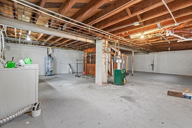 unfinished basement featuring concrete block wall, a heating unit, washing machine and dryer, and gas water heater