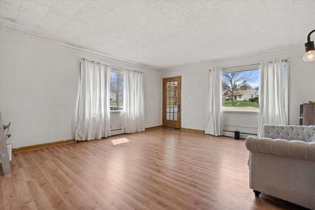 living area with a wealth of natural light, ornamental molding, and light wood-type flooring