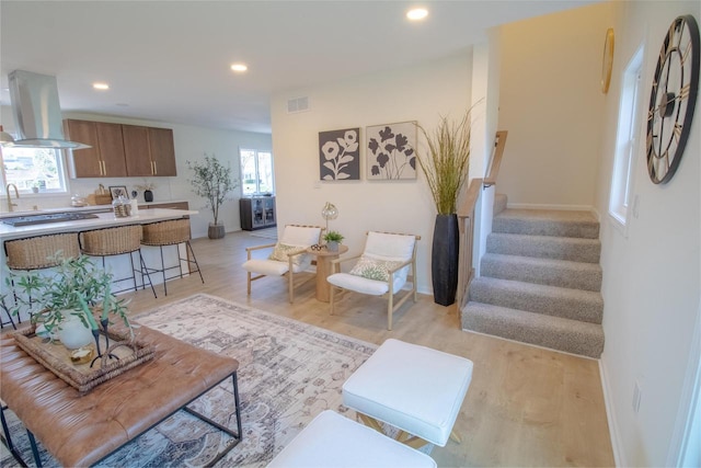 living room featuring stairs, visible vents, recessed lighting, and light wood-style floors