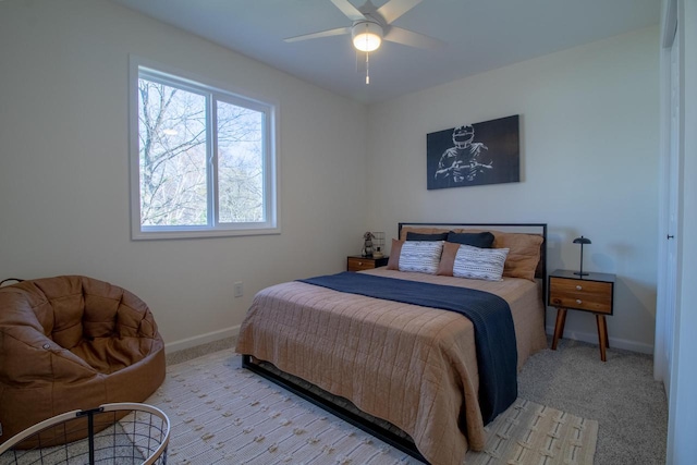 bedroom with ceiling fan, baseboards, and light carpet