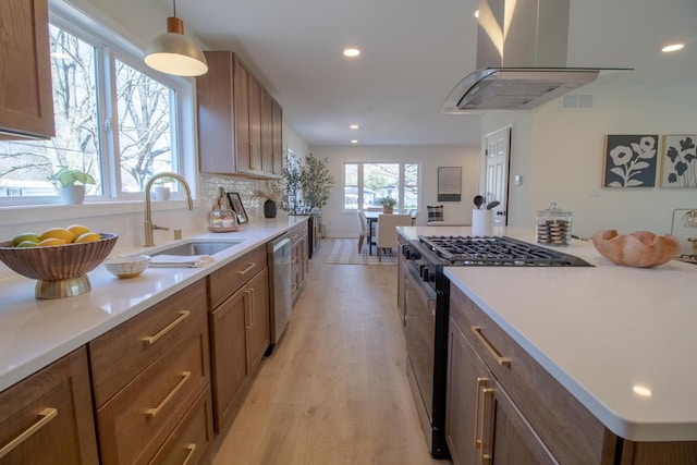 kitchen with recessed lighting, black range with gas stovetop, dishwasher, island range hood, and light wood-type flooring