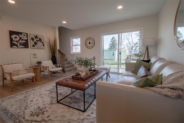 living area featuring light wood-type flooring, recessed lighting, and stairs