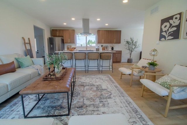 living area featuring light wood-type flooring, visible vents, and recessed lighting