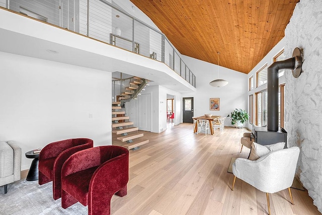 8226 Scott Rd, Cross Plains, WI 53528 - living area with a wood stove, wood finished floors, a towering ceiling, wood ceiling, and stairway