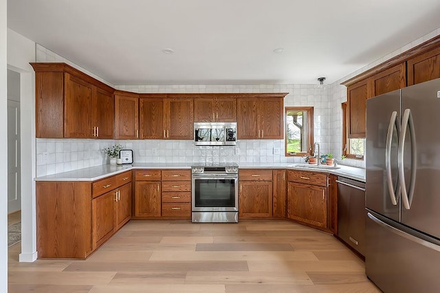 8226 Scott Rd, Cross Plains, WI 53528 - kitchen with a sink, light wood finished floors, light countertops, brown cabinetry, and stainless steel appliances