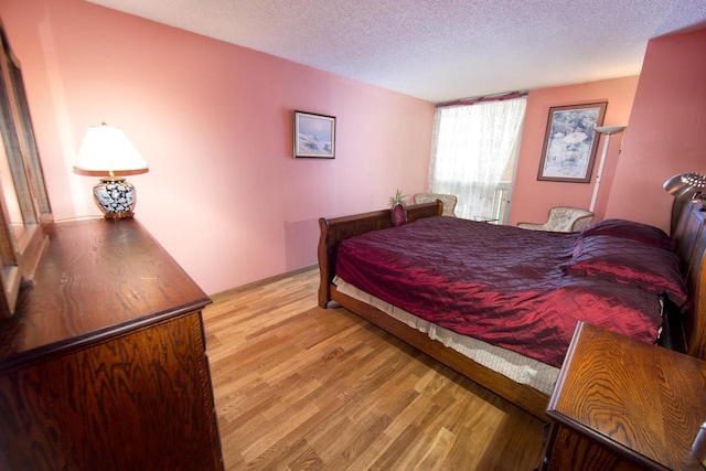 bedroom featuring light wood-style floors and a textured ceiling