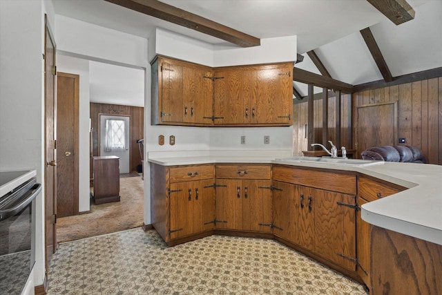 618 W Main St, Waterford, WI 53185 - kitchen featuring stainless steel electric stove, brown cabinetry, a sink, light countertops, and wooden walls