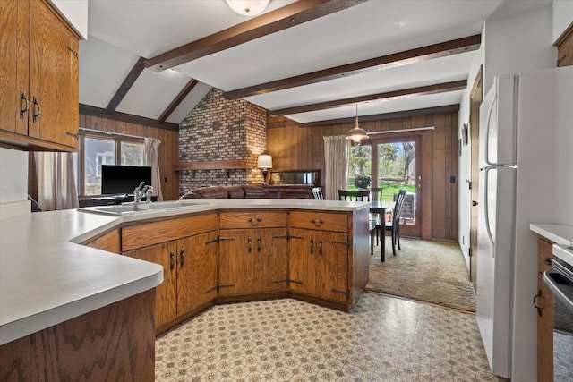 618 W Main St, Waterford, WI 53185 - kitchen featuring light countertops, brown cabinets, wood walls, a peninsula, and freestanding refrigerator