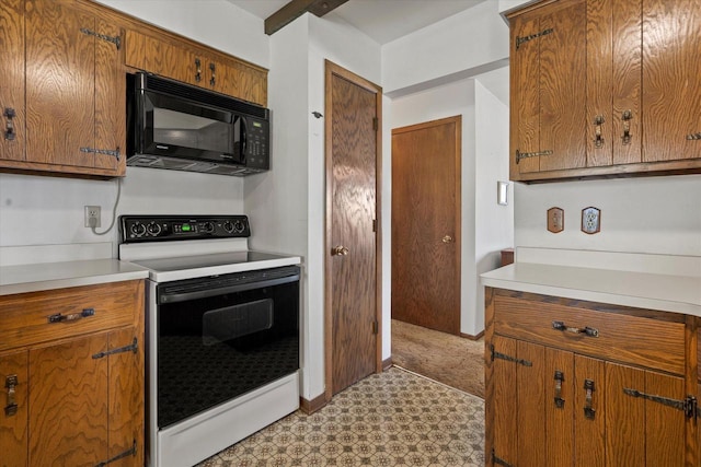 618 W Main St, Waterford, WI 53185 - kitchen with electric range, black microwave, light floors, and brown cabinets