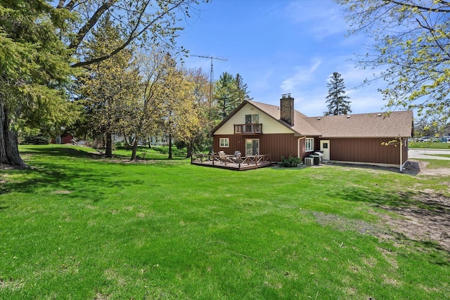 618 W Main St, Waterford, WI 53185 - rear view of property featuring a chimney, a deck, a yard, and central AC unit