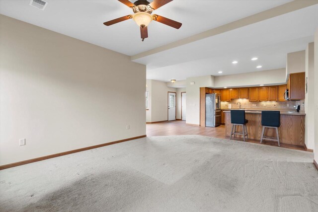 unfurnished living room featuring recessed lighting, light colored carpet, ceiling fan, baseboards, and visible vents