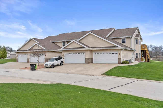 view of front of home featuring brick siding, roof with shingles, a front yard, concrete driveway, and an attached garage