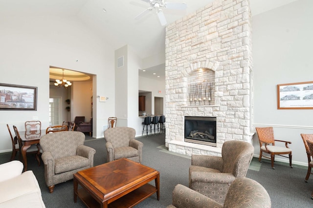 living area featuring a fireplace, carpet flooring, baseboards, visible vents, and high vaulted ceiling