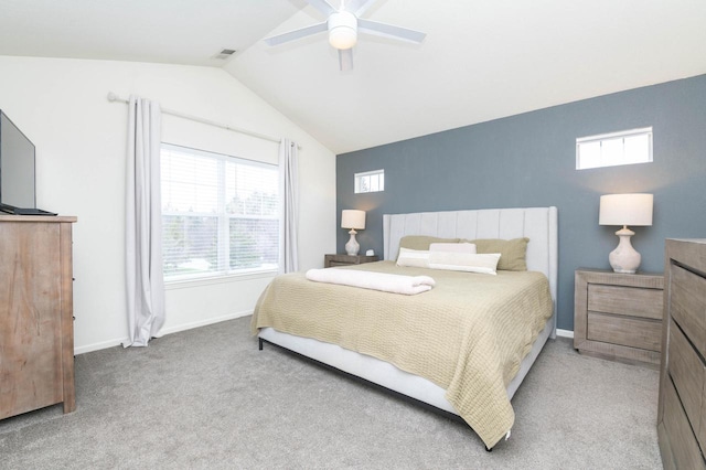 bedroom featuring lofted ceiling, light colored carpet, baseboards, and multiple windows