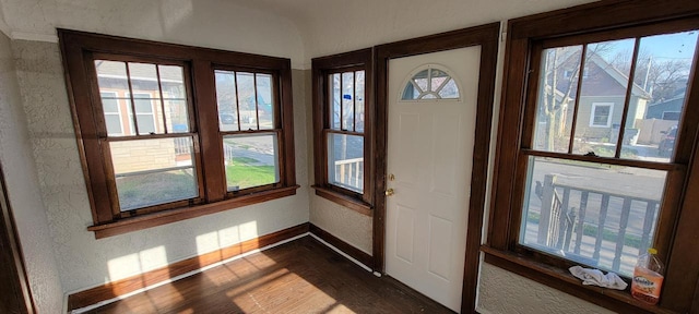 4226 W Sieben Pl, Milwaukee, WI 53216 - doorway to outside featuring dark wood-type flooring, a textured wall, and baseboards