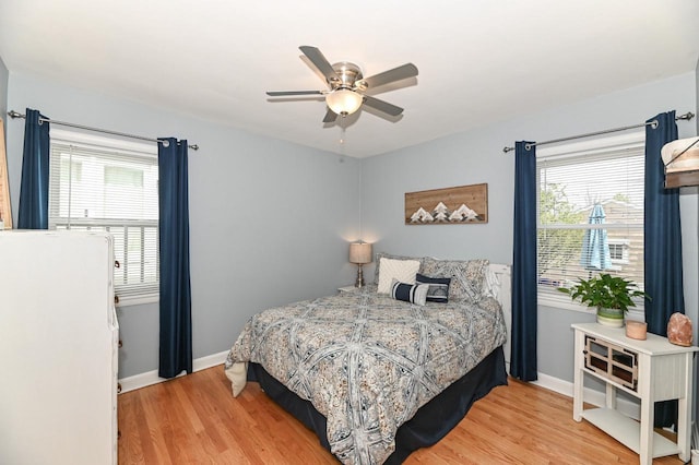 bedroom with a ceiling fan, wood finished floors, and baseboards