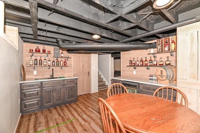 interior space with bar area, light wood-type flooring, wine cooler, and stairs