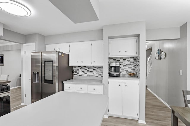 kitchen with white cabinetry, light countertops, stainless steel fridge with ice dispenser, and light wood finished floors