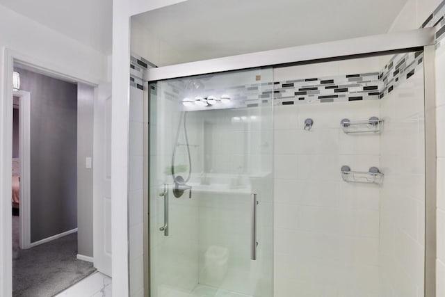 full bathroom with a stall shower, ensuite bath, and baseboards