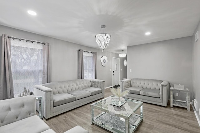 living room featuring light wood finished floors, recessed lighting, a chandelier, and baseboards