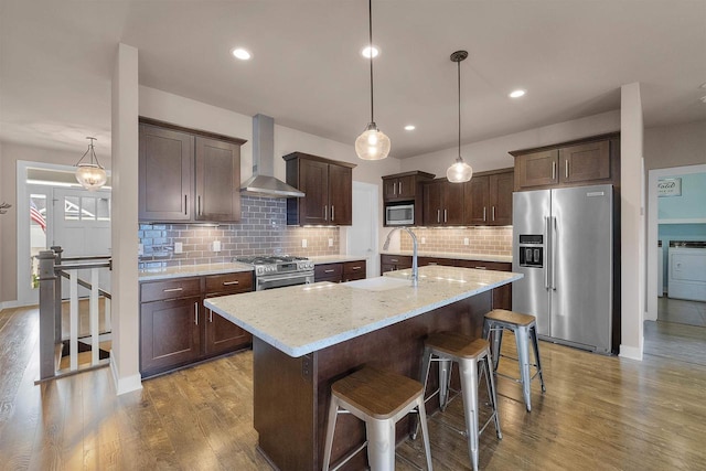 402 Burnt Sienna Dr, Middleton, WI 53562 - kitchen featuring a sink, stainless steel appliances, wall chimney exhaust hood, dark brown cabinets, and wood finished floors