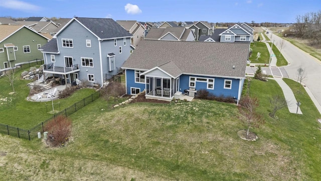 402 Burnt Sienna Dr, Middleton, WI 53562 - rear view of house with a fenced backyard, a residential view, a sunroom, roof with shingles, and a lawn