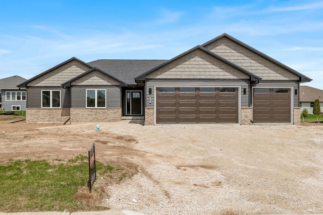 2352 Ryan Ave, Plymouth, WI 53073 - craftsman-style home with dirt driveway, an attached garage, and brick siding
