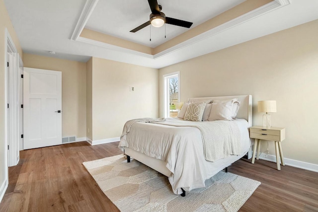 2352 Ryan Ave, Plymouth, WI 53073 - bedroom featuring a raised ceiling, visible vents, baseboards, wood finished floors, and a ceiling fan