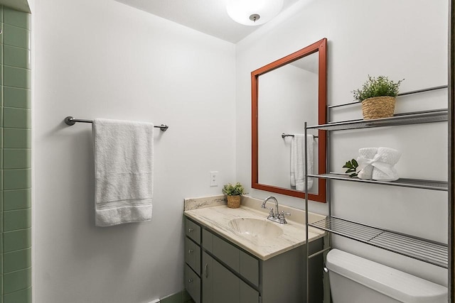 full bathroom with toilet, baseboards, and vanity