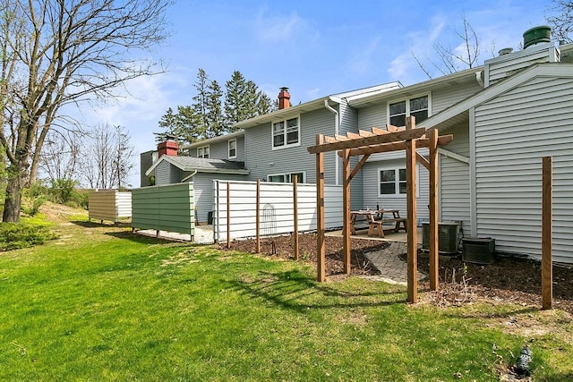 rear view of property featuring a pergola, a chimney, a yard, and a patio area