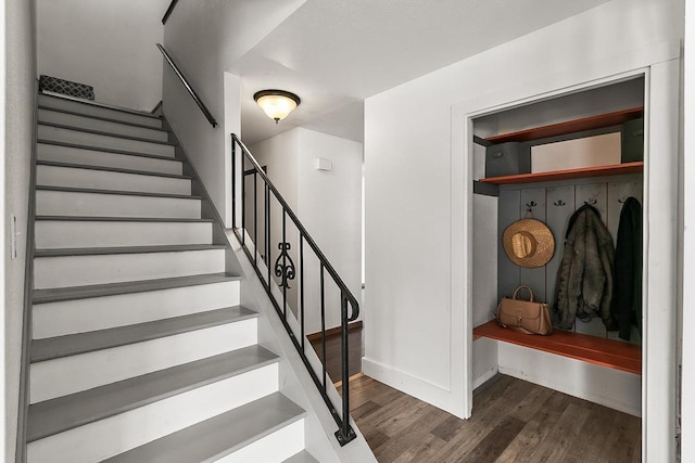 staircase featuring baseboards and wood finished floors