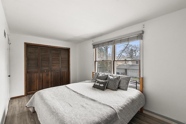 bedroom with baseboards, a closet, and wood finished floors