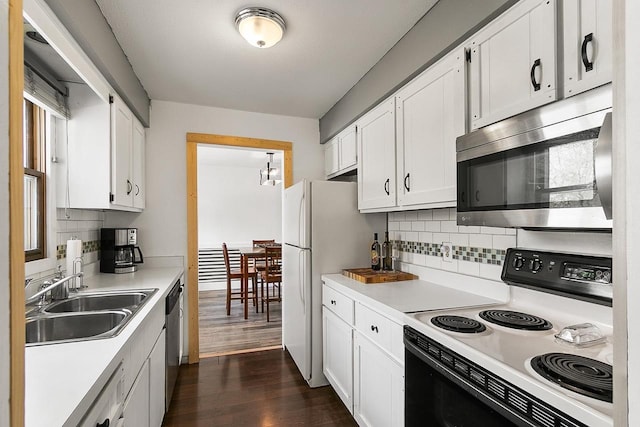 kitchen featuring white cabinets, a sink, stainless steel appliances, dark wood-type flooring, and backsplash